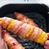 holding Air Fryer bacon wrapped corn on the cob