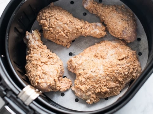 Coated chicken in a single layer in air fryer basket