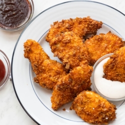 Crispy air fried Doritos chicken tenders on a plate with ranch dressing by bestrecipebox.com