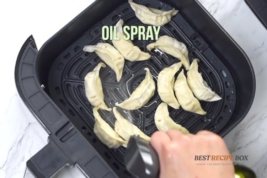 Spraying Uncooked potstickers with oil
