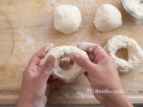 Stretching the dough to form bagel
