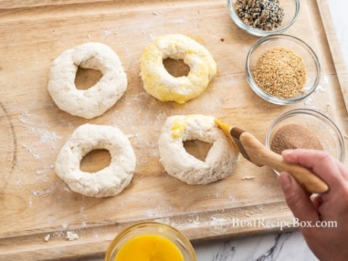Brushing egg on bagels