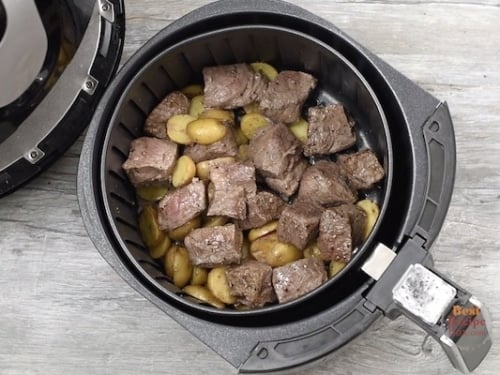 Cooked steak tips and potatoes in air fryer basket