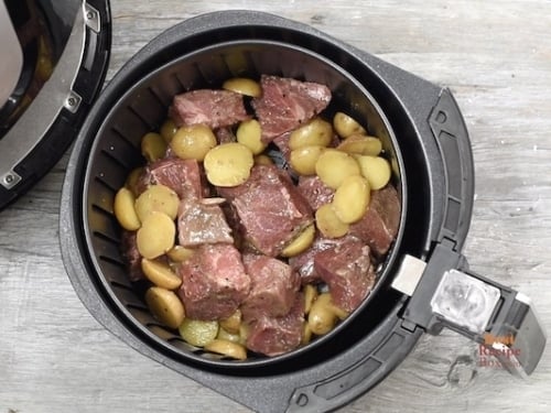 Steak tips and potatoes in air fryer basket
