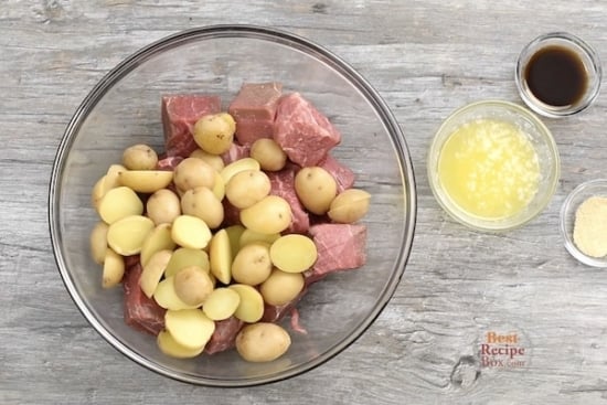 Cut up steak and potatoes in a bowl with flavorings