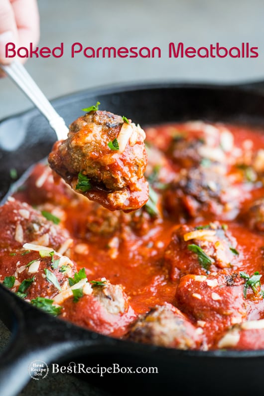 Baked Parmesan Meatballs Recipe for Easy Italian Meatball Dinner in a cast iron skillet with spoon