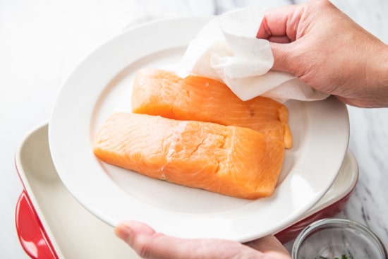 Patting dry salmon with paper towel