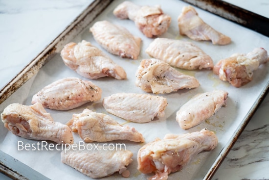 Raw chicken wings on a baking sheet pan
