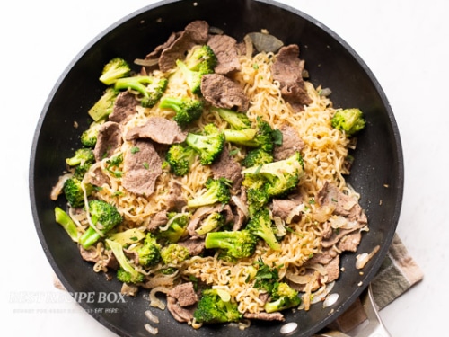 Noodles and seasonings added to pan