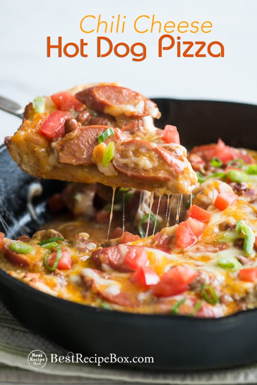 Chili Cheese Hot Dog Pizza Recipe in a cast iron skillet with a spatula