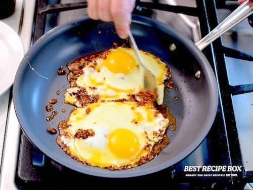 Spooning chili crisp over eggs
