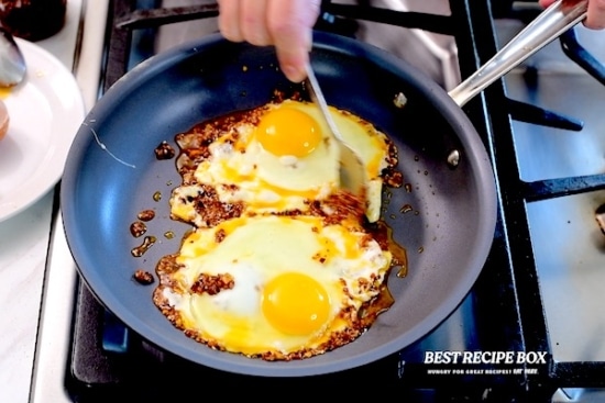 Spooning chili crisp over eggs