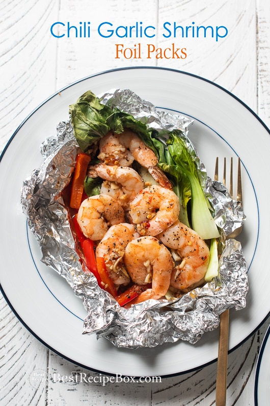 Foil pack garlic shrimp with chili hot sauce on plate