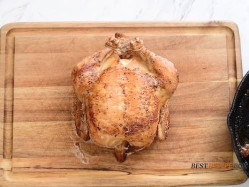 Roasted chicken resting on cutting board