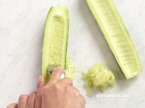 Scooping seeds out of cucumber