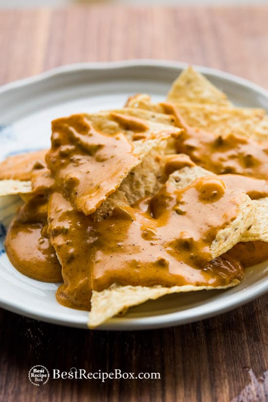 Slow Cooker Green Chile Queso Dip Recipe on a plate with chips 