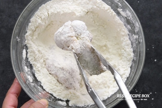Tossing chicken wing in cornstarch-flour mixture
