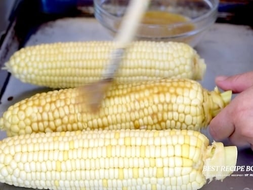 Brushing corn with garlic butter