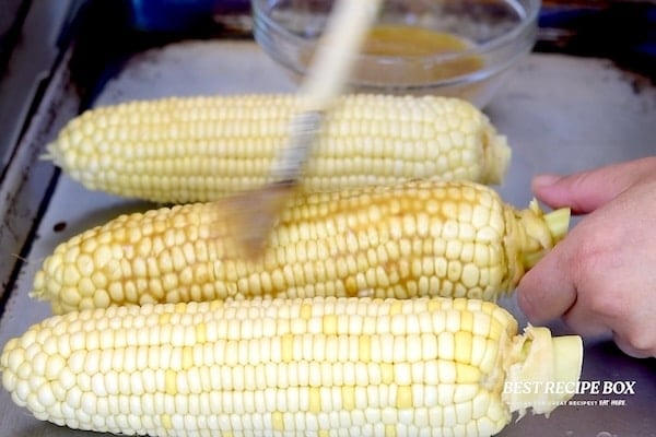 Brushing corn with garlic butter