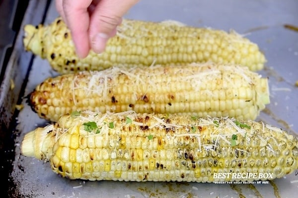 Sprinkling parmesan on corn