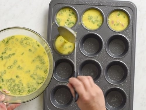 Ladling egg mixture into muffin tray
