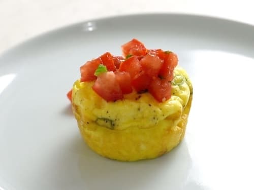 Egg muffin topped with chopped tomatoes