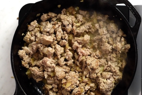 Cooked ground turkey with the onions and garlic in a skillet