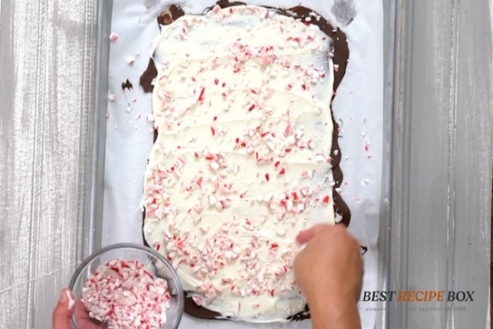 Sprinkling crushed candy canes on chocolate bark