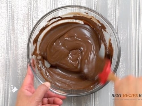 stirring melted chocolate in a glass bowl