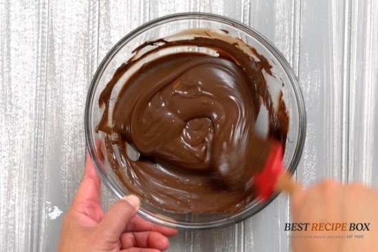 stirring melted chocolate in a glass bowl
