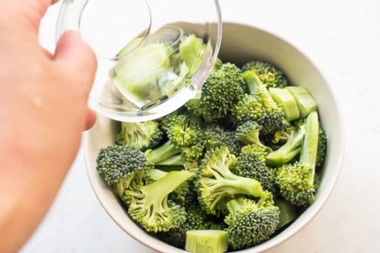 Water being added to raw broccoli in bowl