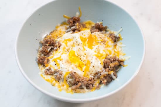 Cheese melted on top of sausage and eggs