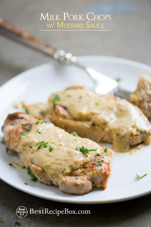 Juicy Pork Chops Braised in Milk with Mustard Sauce on a plate with fork