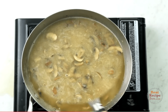 Adding broth to the mushrooms