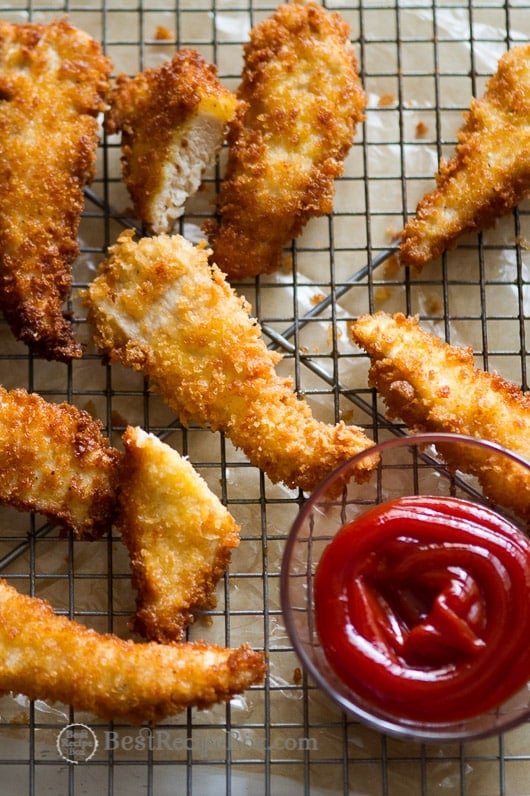 Crispy Juicy Chicken Strips Recipe or fried chicken tenders on a cooling rack