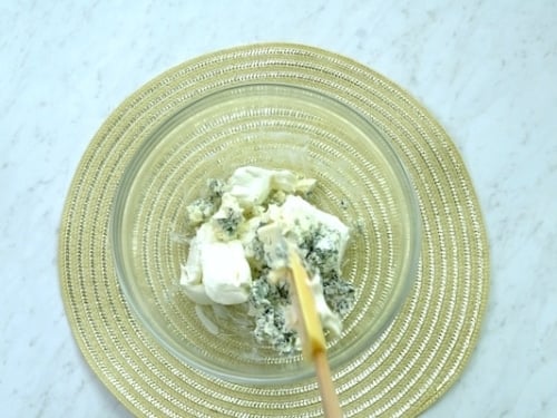 Mixing cream cheese and blue cheese in a bowl