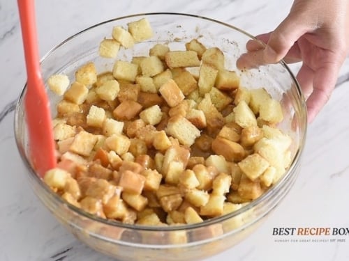 Tossing bread cubes in custard mix