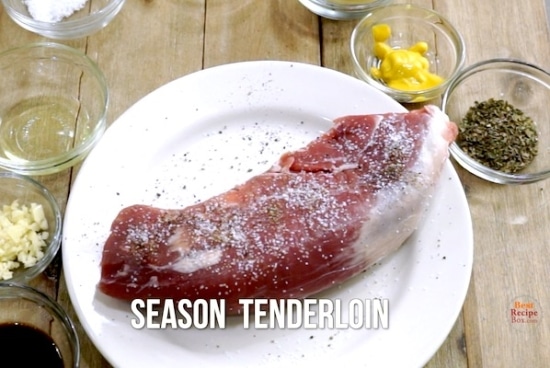 Seasoned raw pork tenderloin on a plate