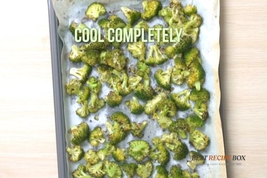 Cooked broccoli pieces on a baking sheet pan