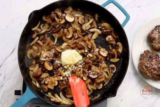 Butter and garlic added to mushrooms and onions