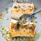 spooning sauce over skillet white fish