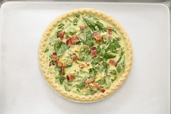 Uncooked quiche on baking tray