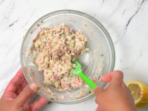 mixing the tuna salad in a bowl