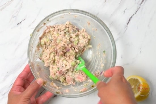 mixing the tuna salad in a bowl