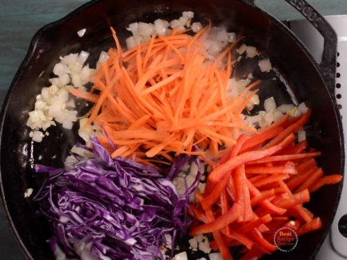 Carrots, bell peppers, and cabbage added to skillet