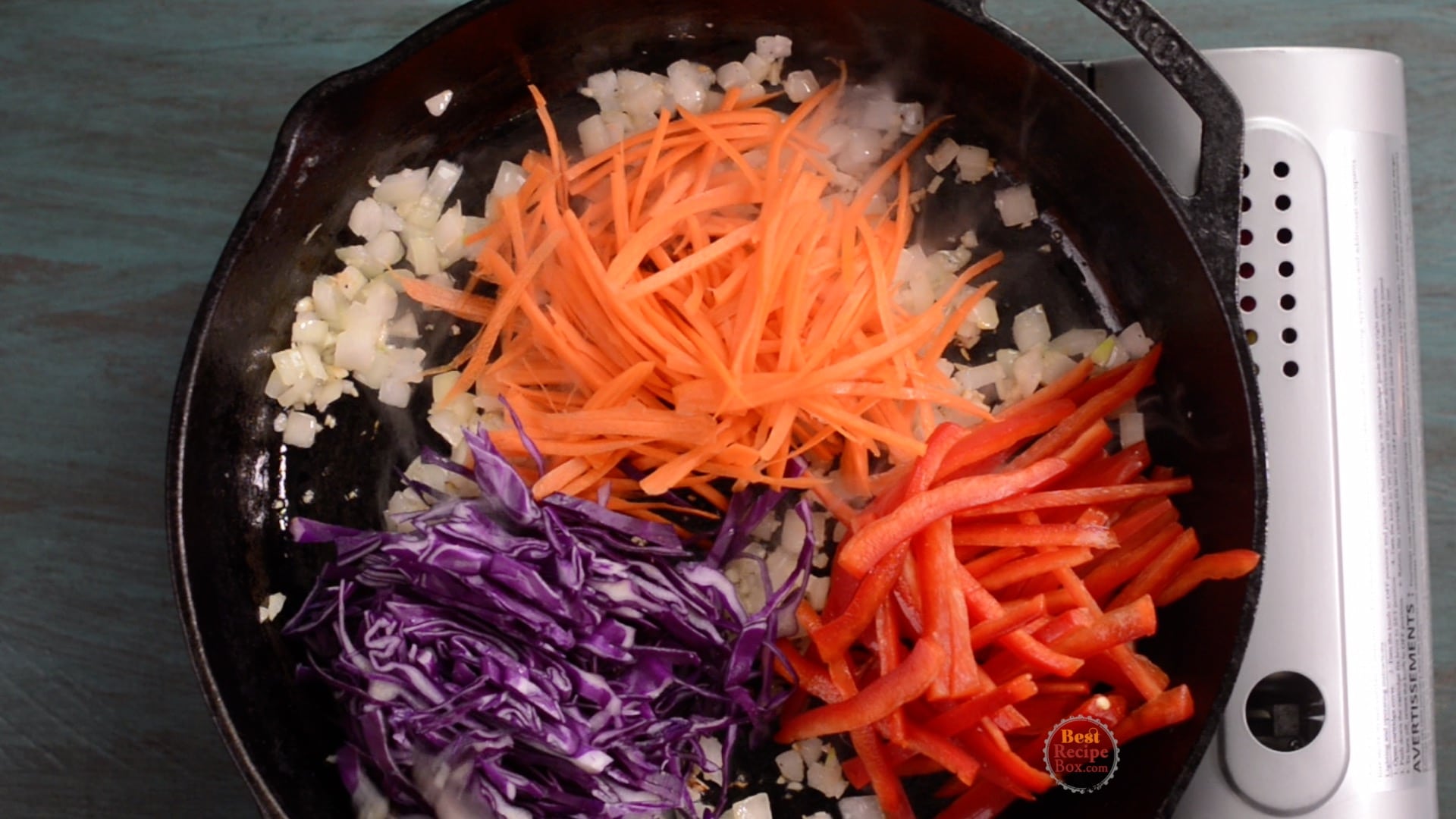 Carrots, bell peppers, and cabbage added to skillet