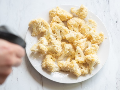 spraying oil on cauliflower