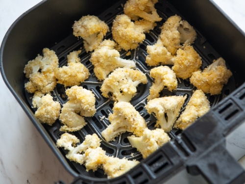 raw cauliflower in air fryer basket