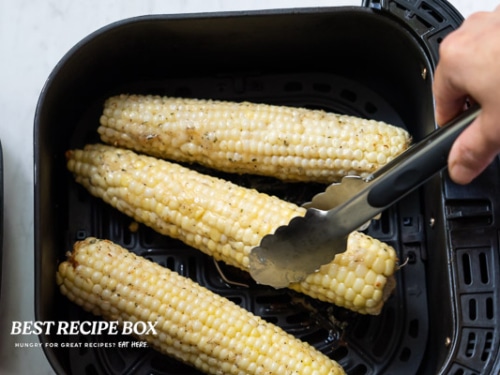 Turning corn with tongs