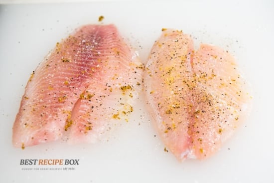 Uncooked white fish filets with lemon pepper seasoning